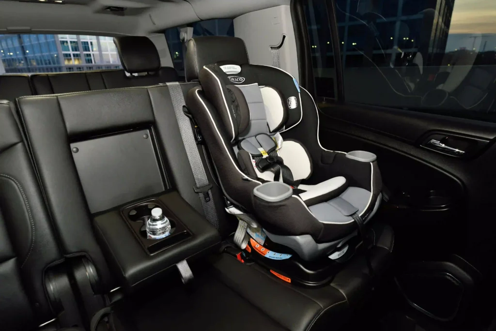 Child car seat installed on the rear seat of a car, secured with the standard factory seat belt and no seat belt extender